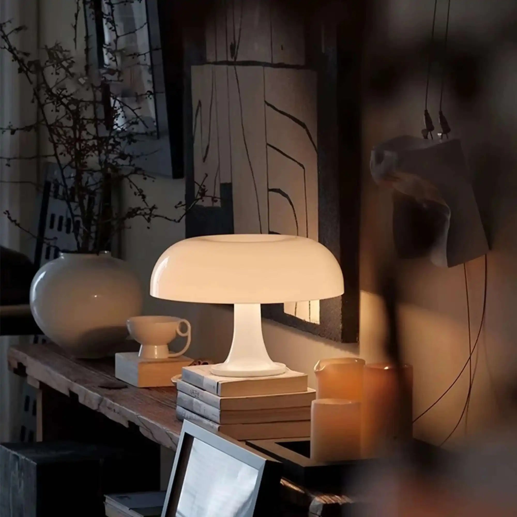 Illuminated mushroom-shaped table lamp on a stack of books.