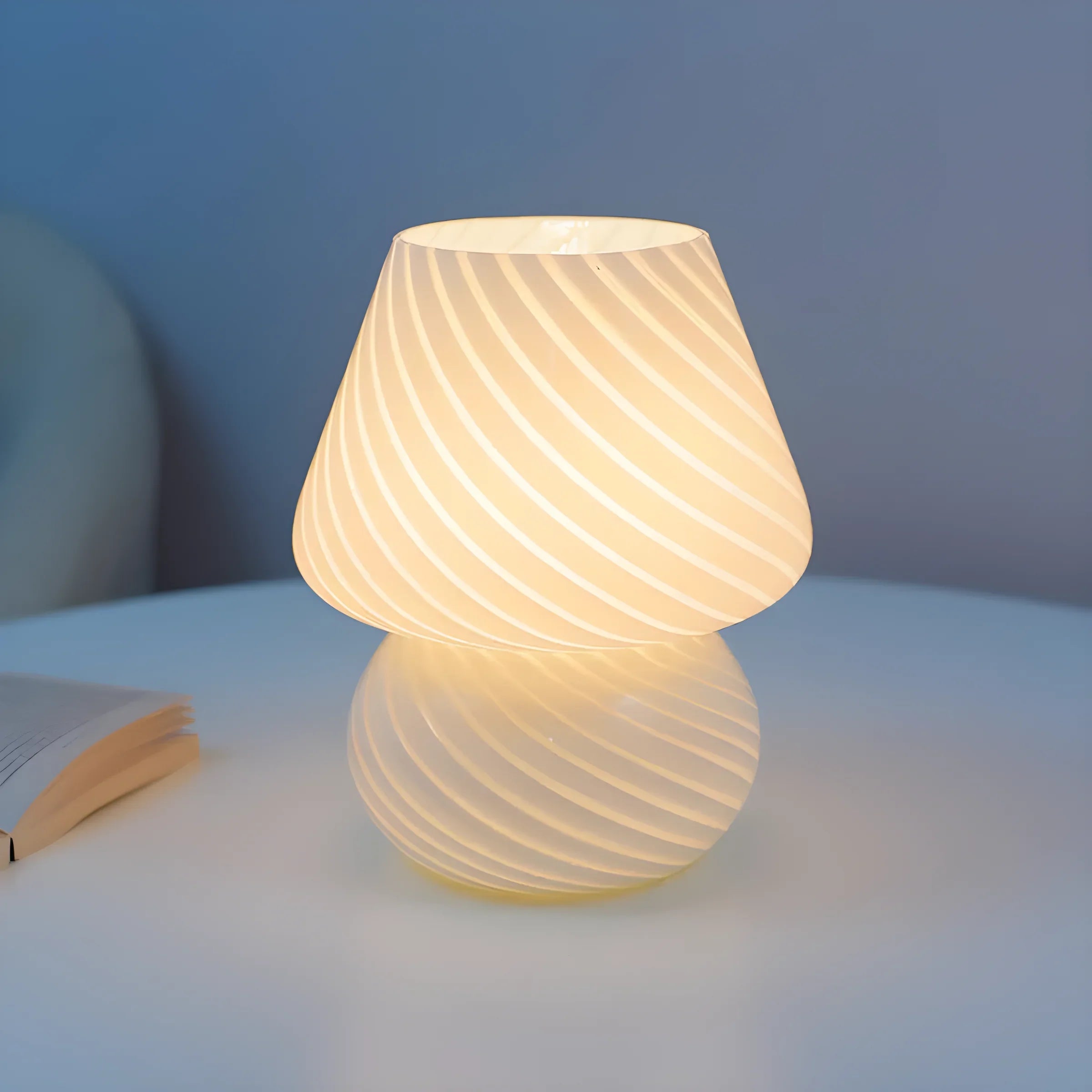 Illuminated mushroom-shaped table lamp with a swirled pattern on its shade.