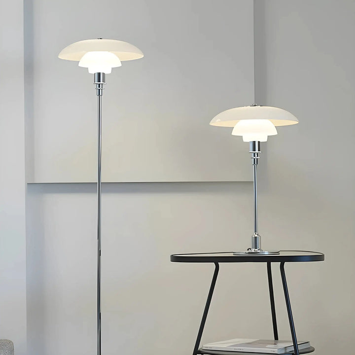 Modern floor and table lamps with tiered white shades and chrome stems.