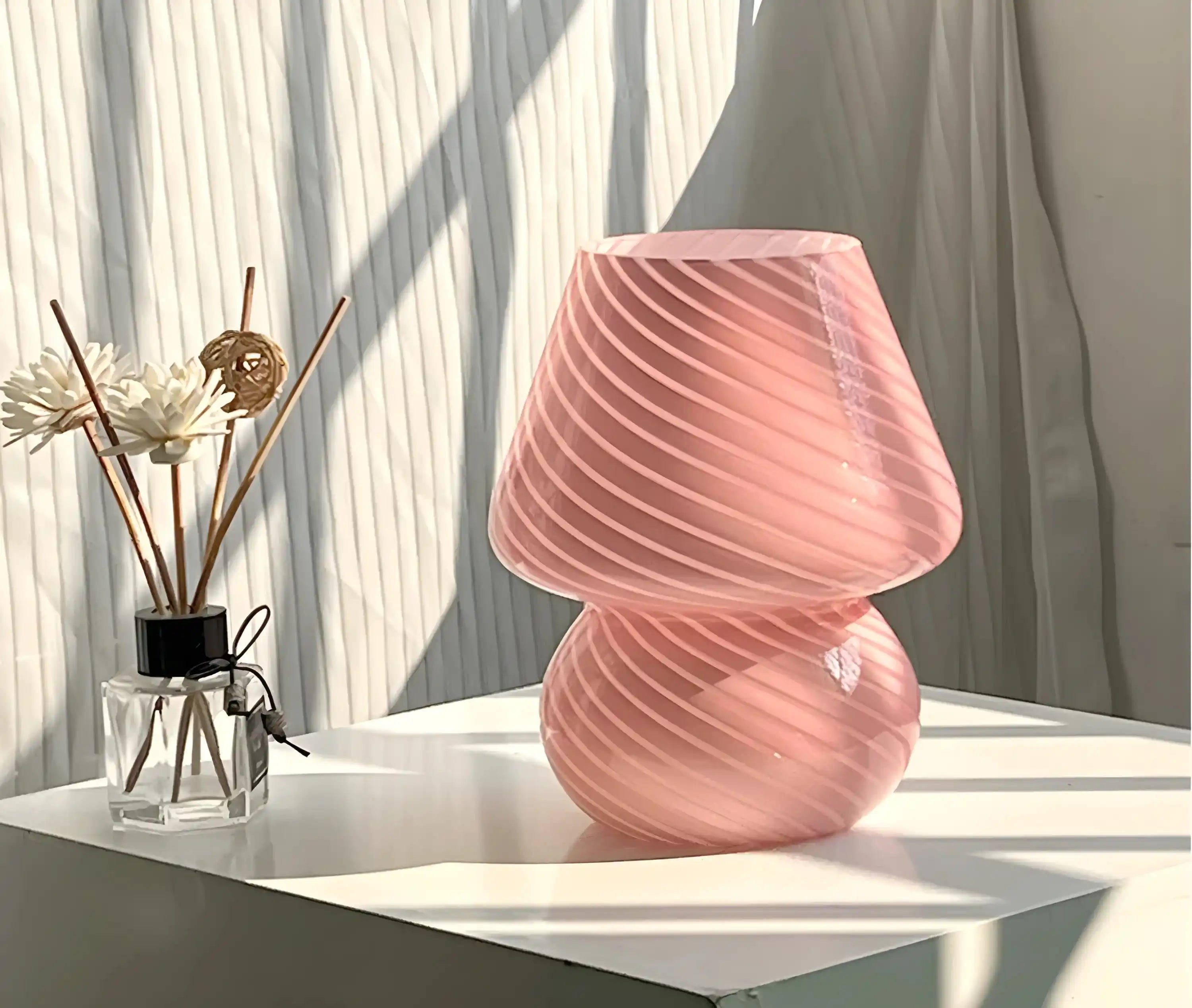 Pink glass table lamp with a swirled, textured surface.