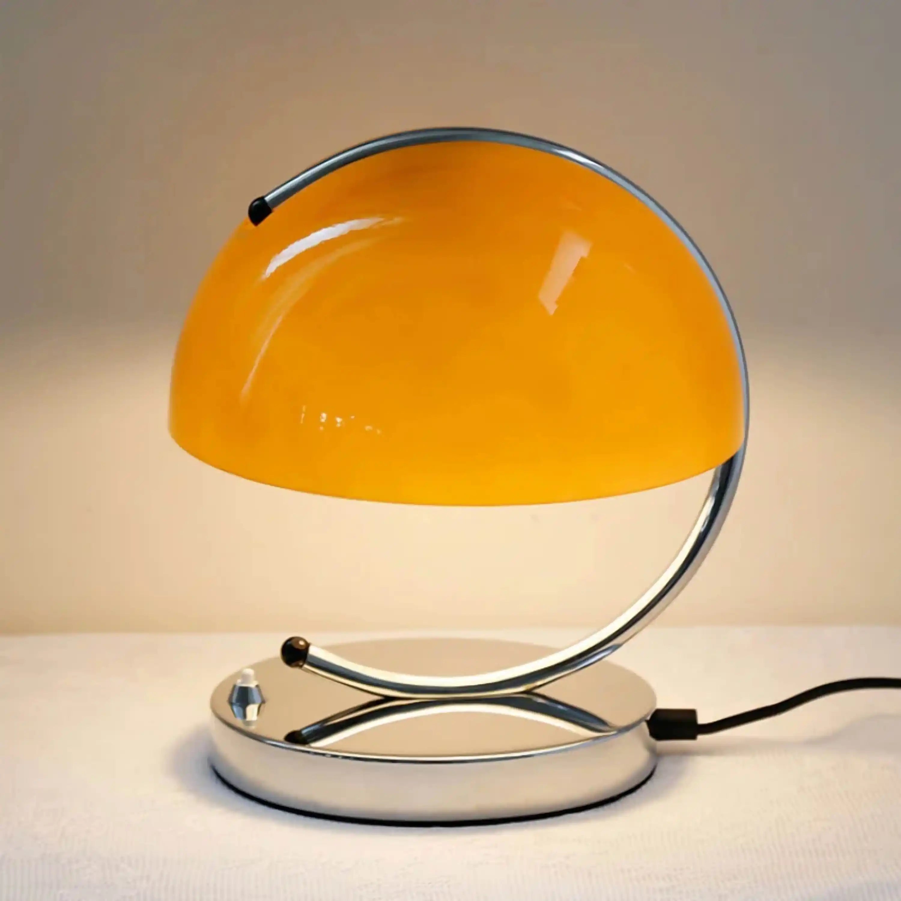 Retro-style desk lamp with a bright orange dome shade and curved chrome base.