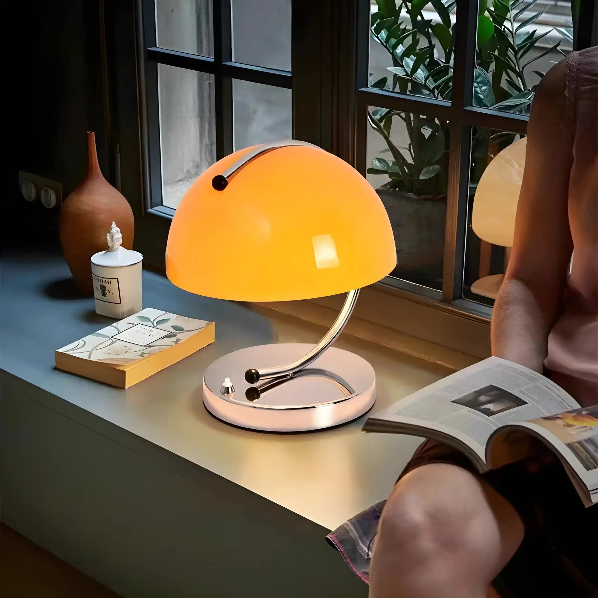 Retro-style table lamp with a bright orange dome shade and curved metal base.