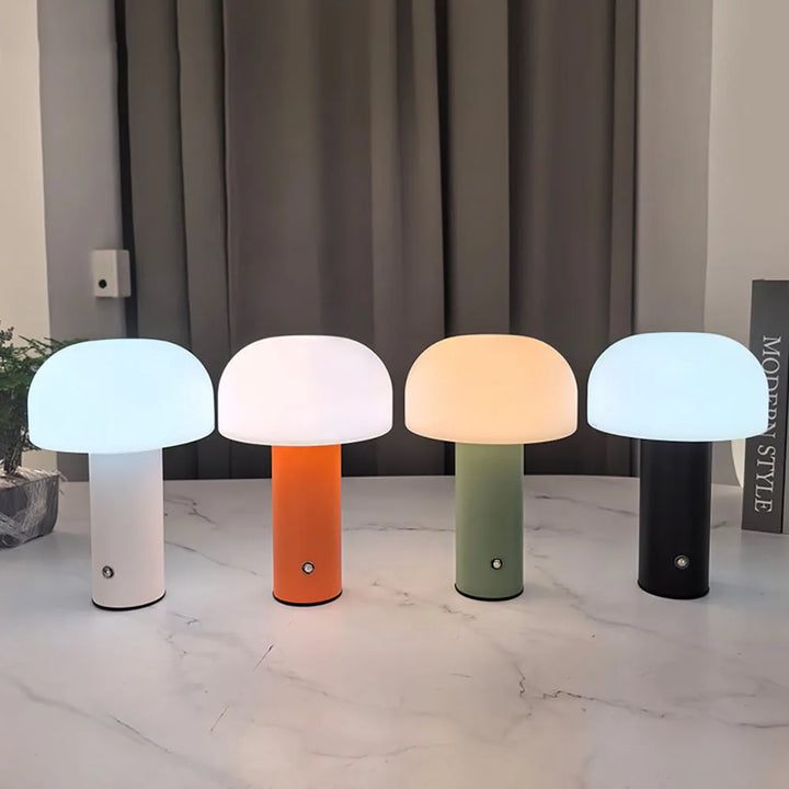 Set of four mushroom-shaped table lamps with colorful bases and glowing domed tops.