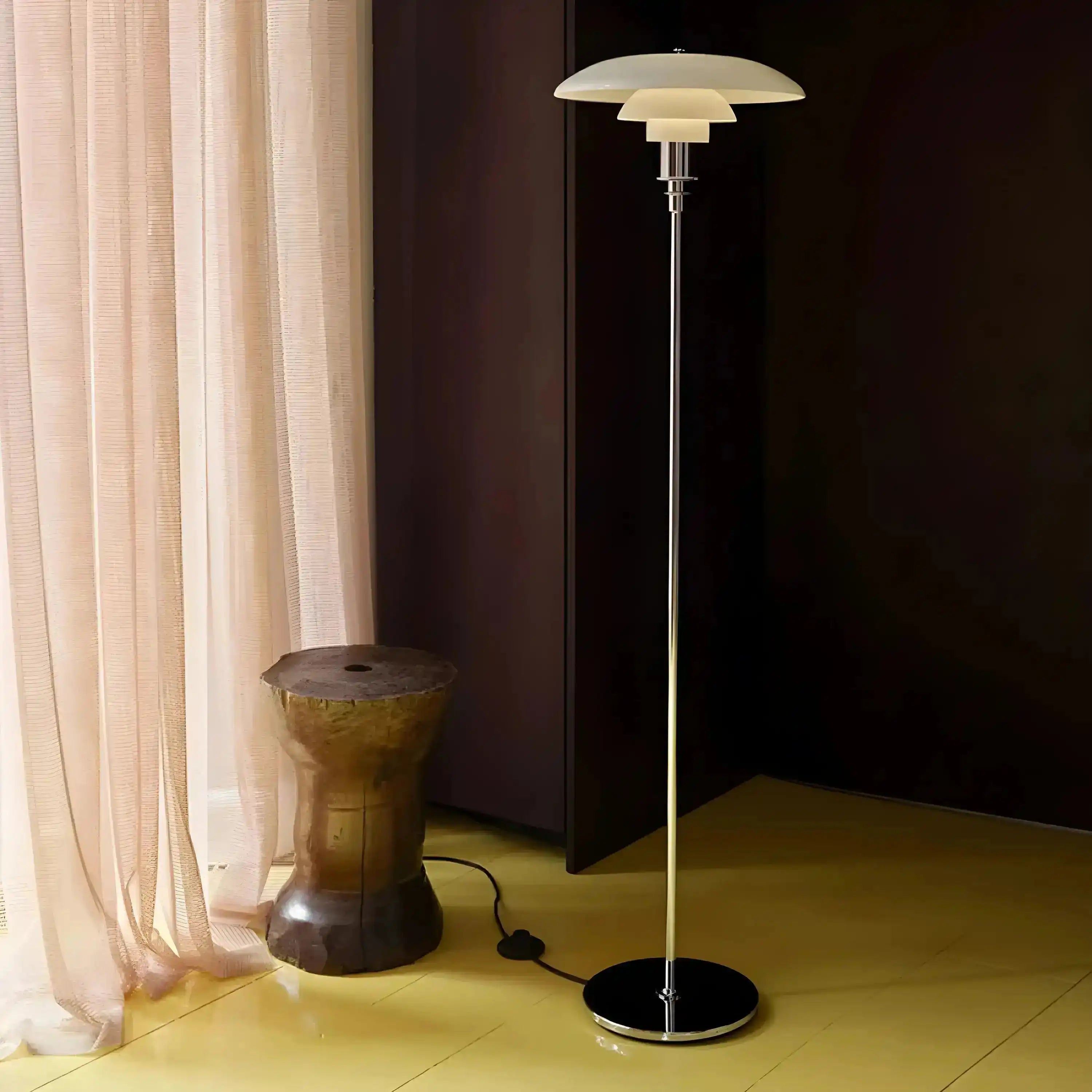 Sleek modern floor lamp with a tiered circular shade atop a slender chrome stand.