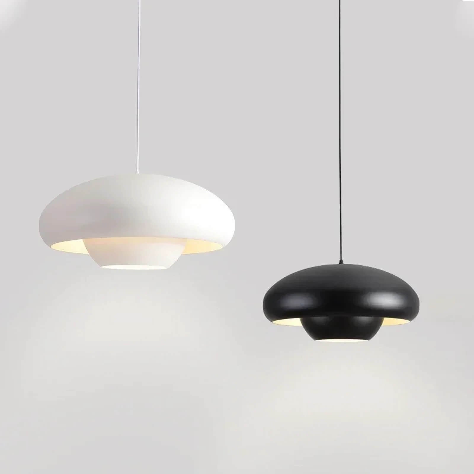 Two modern pendant light fixtures, one white and one black, with rounded disc-like shapes.