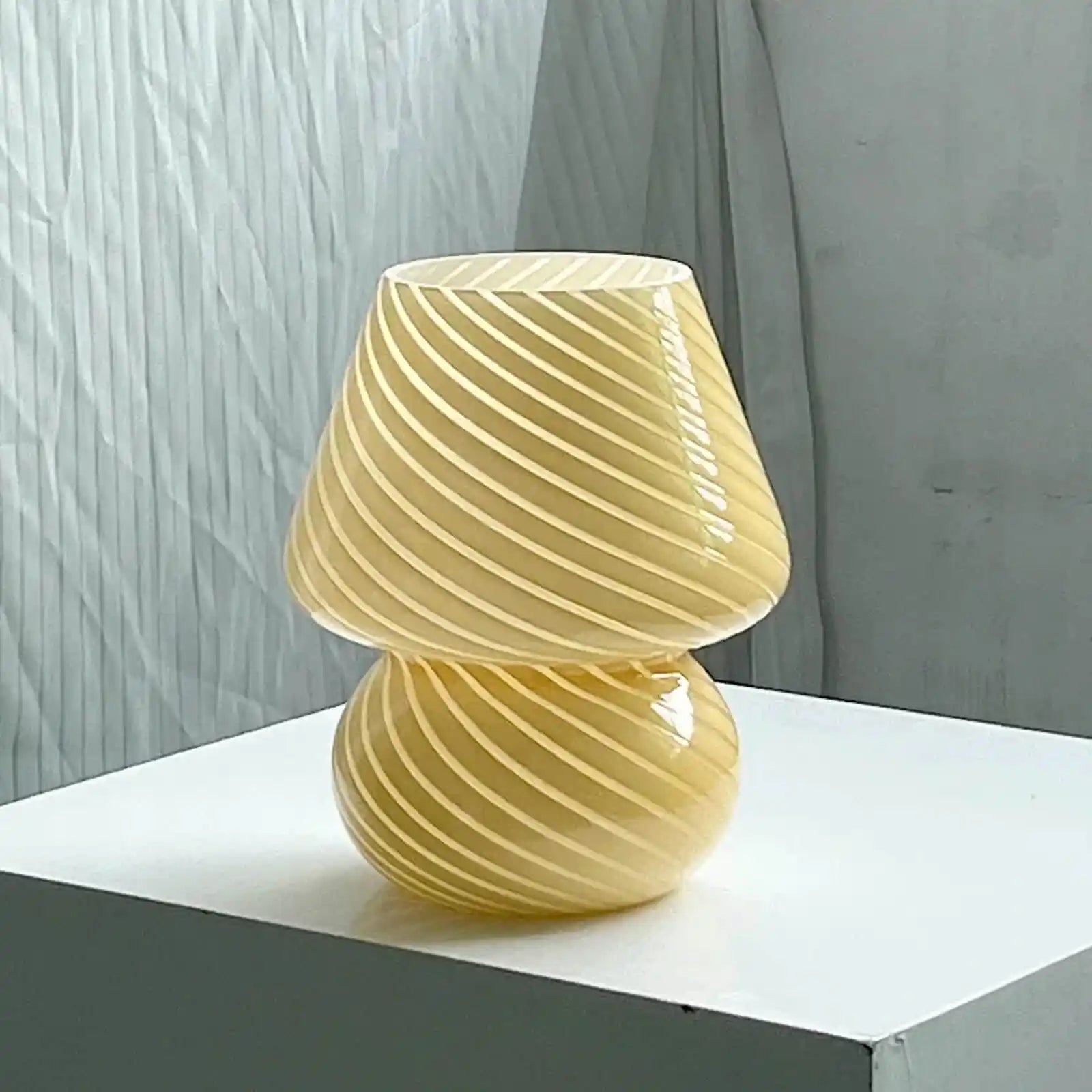 Yellow glass mushroom-shaped lamp with spiral ridges.