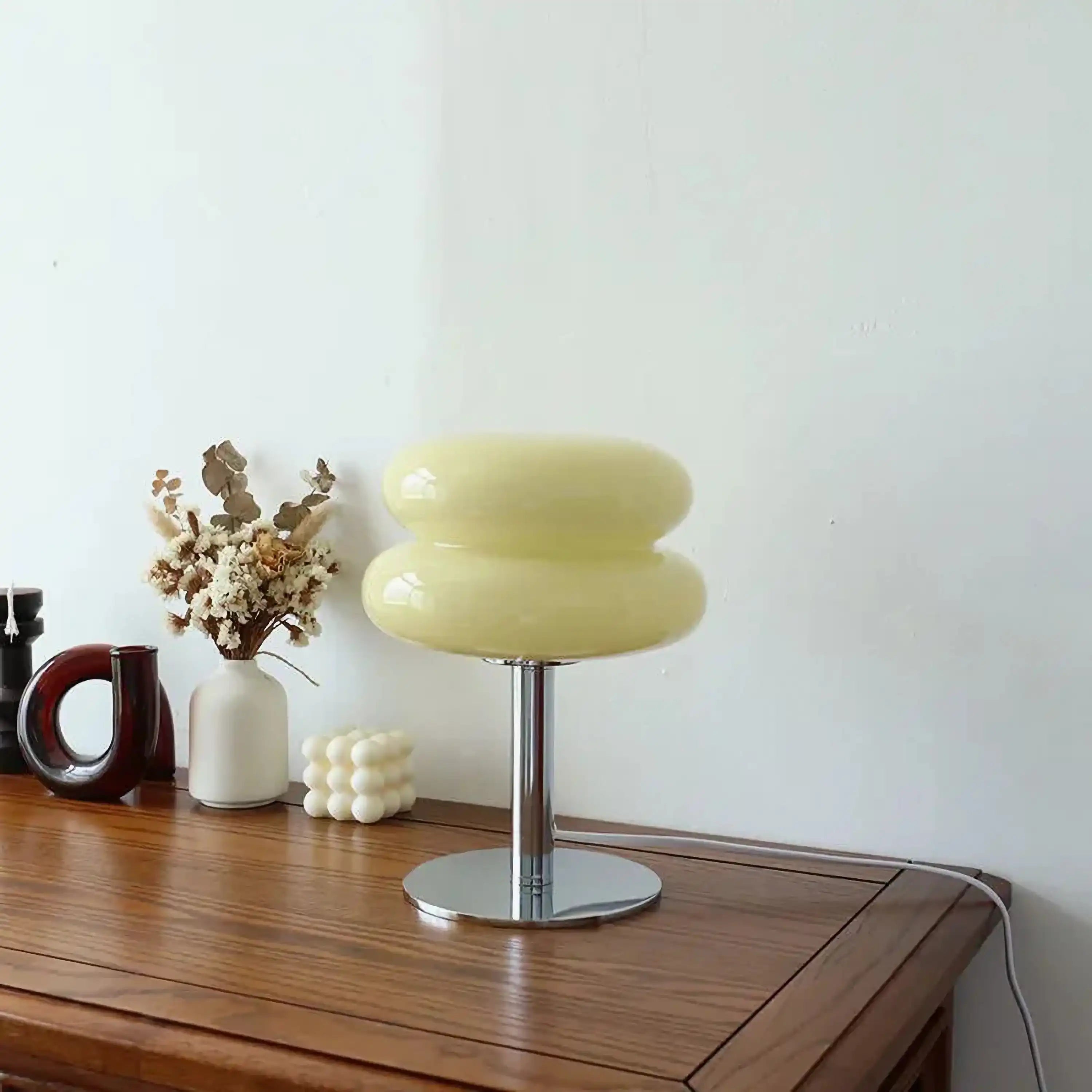 Modern table lamp with a pale yellow, mushroom-shaped shade on a metal base.